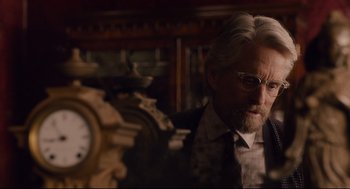 Movie still from “Ant-Man” (2015), directed by Peyton Reed – An older man in a suit standing next to a clock; Close Up shot, Over the shoulder angle
