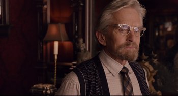 Movie still from “Ant-Man” (2015), directed by Peyton Reed – An old man with a beard wearing glasses and a tie; Close Up shot, Over the shoulder angle