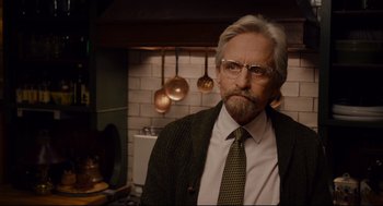 Movie still from “Ant-Man” (2015), directed by Peyton Reed – An older man with a beard wearing a suit and tie; Close Up shot, Over the shoulder angle