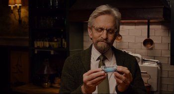 Movie still from “Ant-Man” (2015), directed by Peyton Reed – An older man holding a pack of birth control pills; Close Up shot, Over the shoulder angle