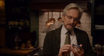 Movie still from “Ant-Man” (2015), directed by Peyton Reed – An older man holding a cell phone in a kitchen; Close Up shot, Over the shoulder angle