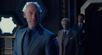 Movie still from “Ant-Man” (2015), directed by Peyton Reed – A man in a suit and tie standing next to another man in a suit and tie; Medium shot, Over the shoulder angle