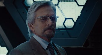 Movie still from “Ant-Man” (2015), directed by Peyton Reed – A person wearing a suit and glasses; Close Up shot, Over the shoulder angle
