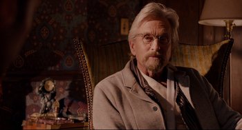 Movie still from “Ant-Man” (2015), directed by Peyton Reed – An older man sitting in a chair wearing glasses; Close Up shot, Over the shoulder angle