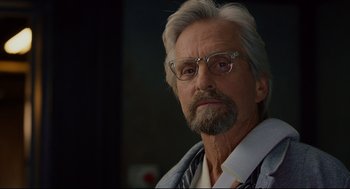 Movie still from “Ant-Man” (2015), directed by Peyton Reed – An older man with a gray beard wearing glasses; Close Up shot, Over the shoulder angle