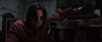 Movie still from “Ant-Man” (2015), directed by Peyton Reed – A man with a bandage on his head and face is leaning against a metal object; Close Up shot, Low angle