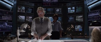 Movie still from “Ant-Man and the Wasp” (2018), directed by Peyton Reed – A man and a woman standing in front of a television; Medium shot, Over the shoulder angle