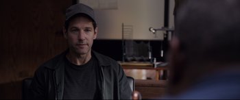 Movie still from “Ant-Man and the Wasp” (2018), directed by Peyton Reed – A person sitting in a chair wearing a hat; Close Up shot, Over the shoulder angle