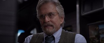 Movie still from “Ant-Man and the Wasp” (2018), directed by Peyton Reed – An older man wearing glasses and a sweater vest; Close Up shot, Over the shoulder angle