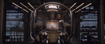 Movie still from “Ant-Man and the Wasp” (2018), directed by Peyton Reed – A man sitting inside of an airplane looking at a computer screen; Wide shot, Over the shoulder angle