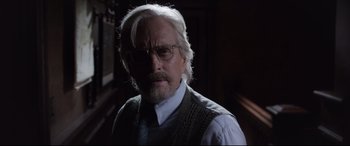 Movie still from “Ant-Man and the Wasp” (2018), directed by Peyton Reed – An older man with white hair wearing glasses and a vest; Close Up shot, Over the shoulder angle
