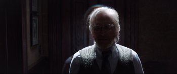 Movie still from “Ant-Man and the Wasp” (2018), directed by Peyton Reed – An old man with a beard wearing glasses and a sweater vest; Medium shot, Over the shoulder angle
