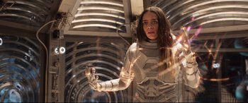 Movie still from “Ant-Man and the Wasp” (2018), directed by Peyton Reed – A woman in a white suit holding something in her hand; Medium shot, Low angle