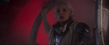 Movie still from “Ant-Man and the Wasp” (2018), directed by Peyton Reed – A woman holding a bow and arrow in front of a red wall; Medium shot, Low angle