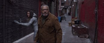 Movie still from “Ant-Man and the Wasp” (2018), directed by Peyton Reed – A man walking down the street wearing a brown jacket; Medium shot, Over the shoulder angle