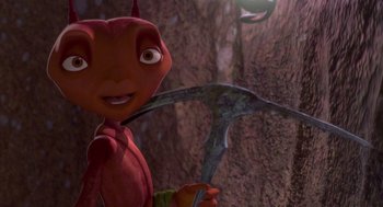 Movie still from “Antz” (1998), directed by Tim Johnson – A red creature holding a pick in its mouth; Close Up shot, High angle