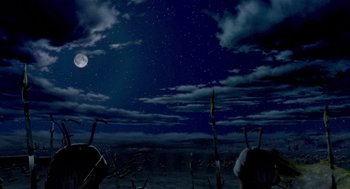 Movie still from “Antz” (1998), directed by Tim Johnson – Two people standing on the beach under a cloudy night sky; Extreme Wide shot, High angle