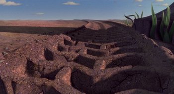 Movie still from “Antz” (1998), directed by Tim Johnson – An image of a dirt road going through the desert; Extreme Wide shot, High angle
