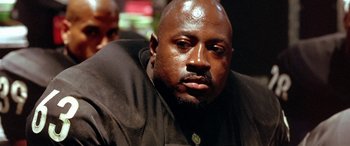 Movie still from “Any Given Sunday” (1999), directed by Oliver Stone – A person wearing a black shirt; Close Up shot, Low angle