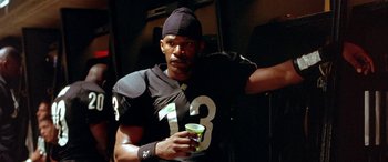 Movie still from “Any Given Sunday” (1999), directed by Oliver Stone – A football player is holding a cup in his hand; Close Up shot, Low angle