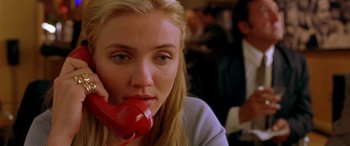 Movie still from “Any Given Sunday” (1999), directed by Oliver Stone – A woman sitting at a table talking on a red phone; Close Up shot, High angle