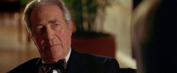 Movie still from “Any Given Sunday” (1999), directed by Oliver Stone – An older man wearing a suit and tie; Close Up shot, Over the shoulder angle
