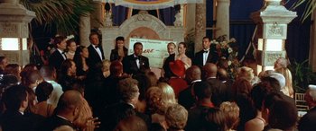 Movie still from “Any Given Sunday” (1999), directed by Oliver Stone – A group of people standing in front of an audience; Medium shot, High angle
