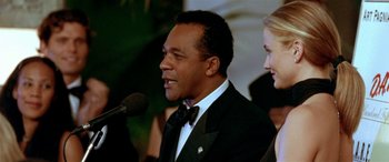 Movie still from “Any Given Sunday” (1999), directed by Oliver Stone – A man standing next to a woman wearing a tuxedo; Close Up shot, Low angle
