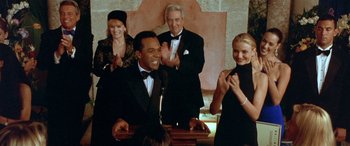 Movie still from “Any Given Sunday” (1999), directed by Oliver Stone – A group of people standing in a room clapping; Medium shot, Low angle
