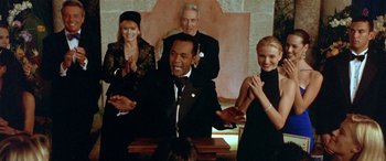 Movie still from “Any Given Sunday” (1999), directed by Oliver Stone – A group of people standing in front of a microphone; Medium shot, Low angle