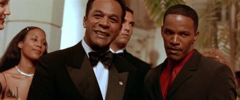 Movie still from “Any Given Sunday” (1999), directed by Oliver Stone – A man in a tuxedo smiling for the camera; Close Up shot, Low angle