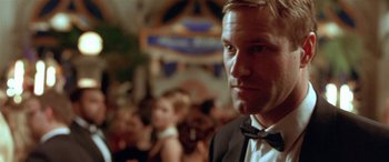 Movie still from “Any Given Sunday” (1999), directed by Oliver Stone – A person wearing a suit and bow tie; Close Up shot, Over the shoulder angle