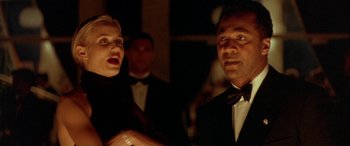 Movie still from “Any Given Sunday” (1999), directed by Oliver Stone – A man and a woman in black tuxedos in front of a crowd; Close Up shot, Low angle