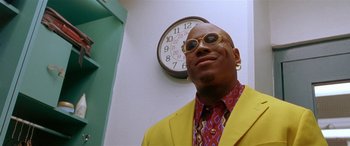 Movie still from “Any Given Sunday” (1999), directed by Oliver Stone – A man in a yellow jacket and a clock; Close Up shot, Low angle