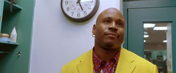 Movie still from “Any Given Sunday” (1999), directed by Oliver Stone – A man in a yellow jacket and a clock; Close Up shot, Low angle