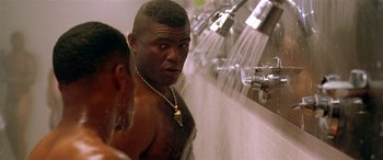 Movie still from “Any Given Sunday” (1999), directed by Oliver Stone – A man with a gold chain around his neck is taking a shower; Close Up shot, Low angle