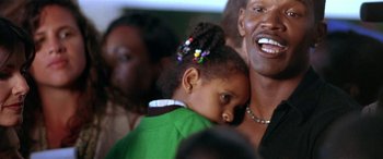Movie still from “Any Given Sunday” (1999), directed by Oliver Stone – A man holding a young girl in his arms; Close Up shot, Low angle