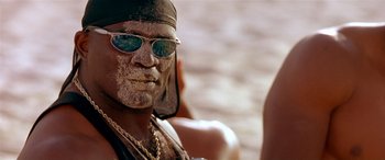 Movie still from “Any Given Sunday” (1999), directed by Oliver Stone – A person wearing sunglasses and a hat; Close Up shot, Low angle