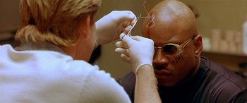 Movie still from “Any Given Sunday” (1999), directed by Oliver Stone – A bald man getting his head shaved by a barber; Close Up shot, High angle