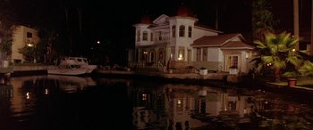 Movie still from “Any Given Sunday” (1999), directed by Oliver Stone – A house on the side of a body of water at night; Extreme Wide shot, Low angle