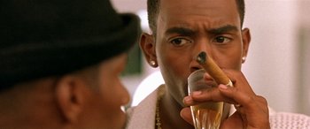 Movie still from “Any Given Sunday” (1999), directed by Oliver Stone – A person holding a glass of wine and a cigar; Close Up shot, Over the shoulder angle