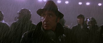 Movie still from “Any Given Sunday” (1999), directed by Oliver Stone – A man in a hat and a black jacket in the rain; Close Up shot, Low angle