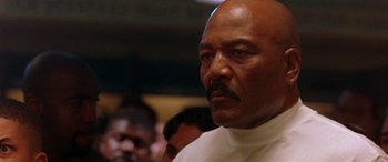 Movie still from “Any Given Sunday” (1999), directed by Oliver Stone – An older man in a white shirt is looking at the camera; Close Up shot, Low angle