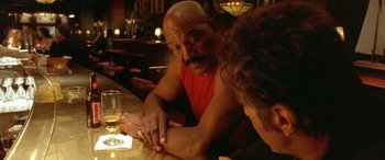 Movie still from “Any Given Sunday” (1999), directed by Oliver Stone – A man and a woman sitting at a table; Medium shot, Over the shoulder angle