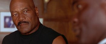 Movie still from “Any Given Sunday” (1999), directed by Oliver Stone – A man's face in a black shirt; Close Up shot, Low angle
