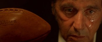 Movie still from “Any Given Sunday” (1999), directed by Oliver Stone – An older man with a football in front of him; Extreme Close Up shot, Low angle