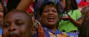Movie still from “Any Given Sunday” (1999), directed by Oliver Stone – An older woman wearing a blue hat is laughing; Close Up shot, Low angle