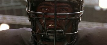 Movie still from “Any Given Sunday” (1999), directed by Oliver Stone – A man wearing a football helmet; Extreme Close Up shot, Low angle