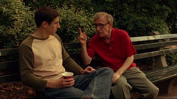 Movie still from “Anything Else” (2003), directed by Woody Allen – Two men sitting on a park bench one of which is pointing; Medium shot, Over the shoulder angle