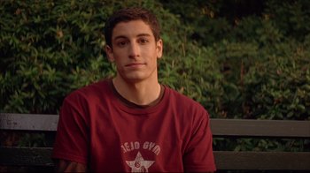 Movie still from “Anything Else” (2003), directed by Woody Allen – A man sitting on top of a wooden park bench; Close Up shot, Low angle